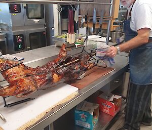 Roast Lamb on a spit with a chef in the kitchen