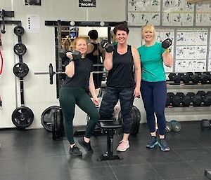 Three woman holding dumbells at the gym