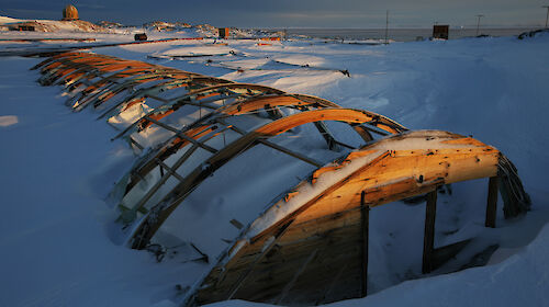 The rusted frame of building covered in snow