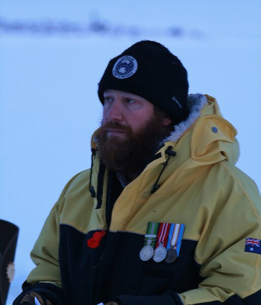 Close up of bearded man, wearing AAD beanie and goose down jacket, wearing service medals and red poppy.