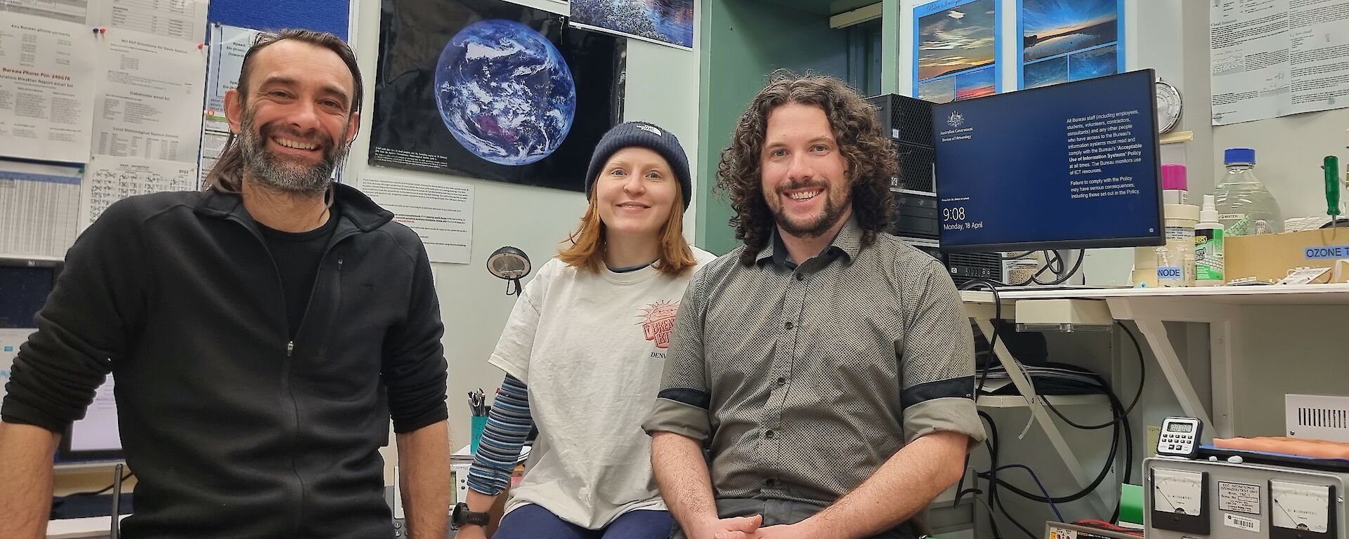 Three people in a weather observing office