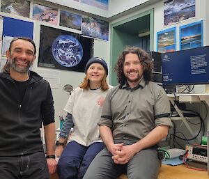 Three people in a weather observing office