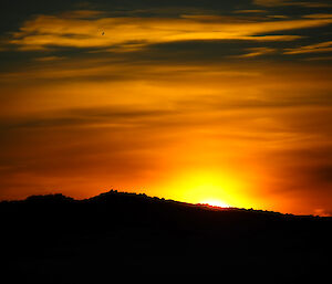 Bright orange and yellow sunset over shadow of land