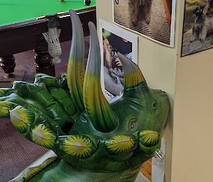 Inflatable triceratops toy stands up against pole which has pictures of pets posted on it