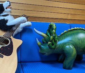 Inflatable triceratops toy and is sung too by border collie stuffed toy 'holding' a guitar