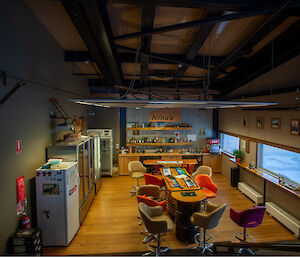 A bar areas including tables, chairs and fridges