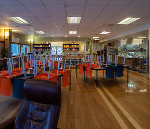 A large area with tables and chairs and commercial kitchen