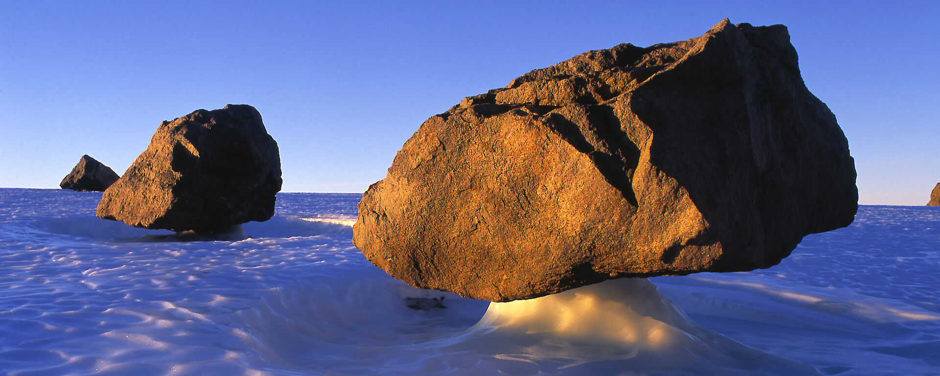 Three large rocks held aloft by ice pillars.