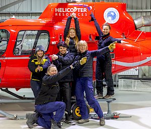 A group of woman in front of a helicopter