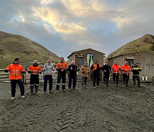 A group of expeditioners line up outside to start some push ups