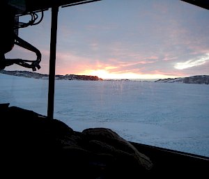 Windscreen outline of a Hagglunds looking out on snow, ice and the sky