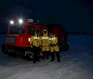 3 expeditioners in front of a Red Hagglunds