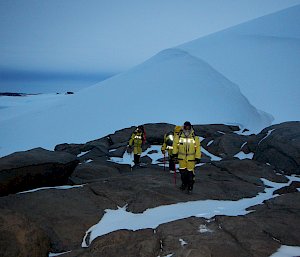 Expeditioners walking on rocks and snow