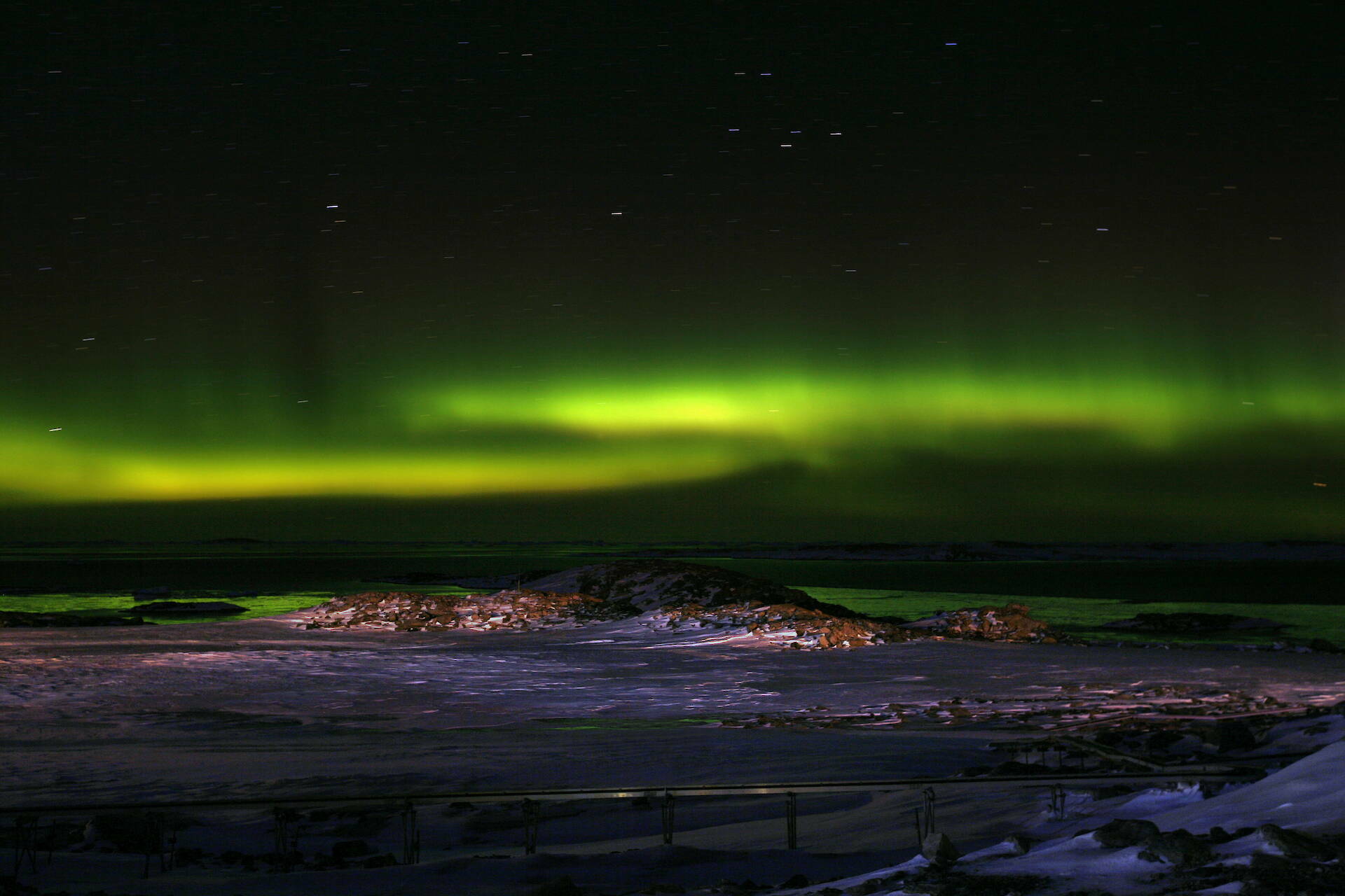 Green aurora over an ice-filled bay at Casey.