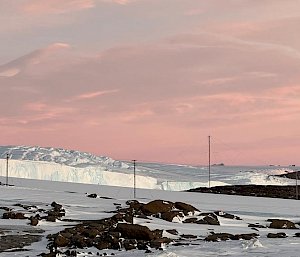 Twilight lights up the sky above the ice cliffs of west bay with pinks and lilacs