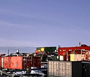 Collection of Antarctic buildings extending up slope, lit with orange light