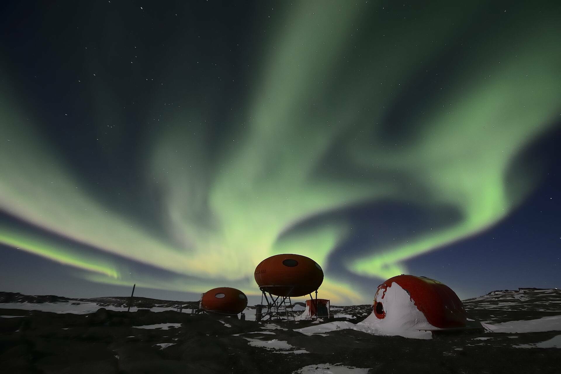 Aurora bands above the googie huts at Béchervaise Island.