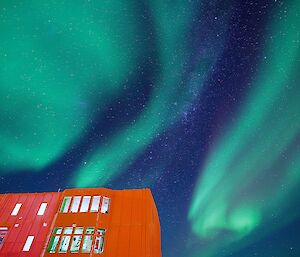 Bottom left corner the red living quarters building, all above green aurora and bright stars