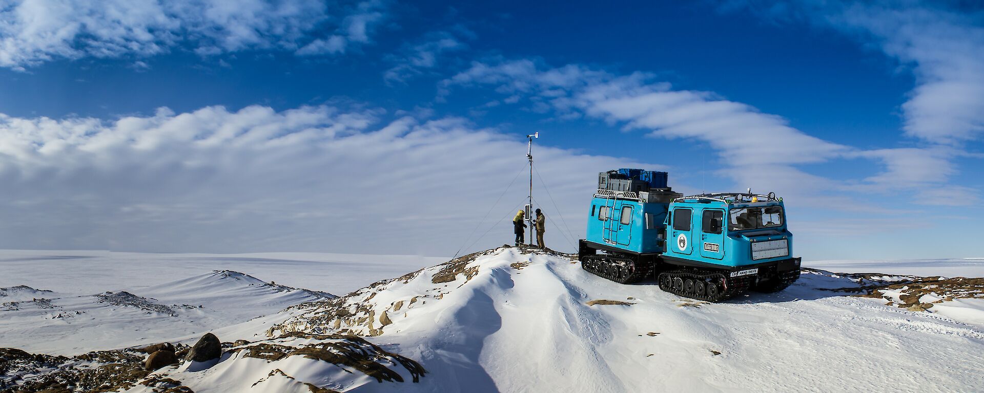 Panorama of blue oversnow vehicle at automatic weather station and view over fast ice