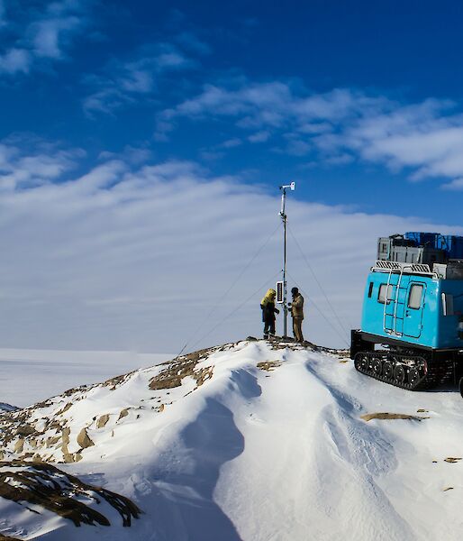 Panorama of blue oversnow vehicle at automatic weather station and view over fast ice