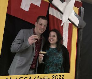 Two people stand with a drink for a toast