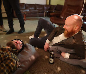 Two guys lazing about on the floor chatting