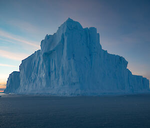 Large tabular iceberg rises up above photographer