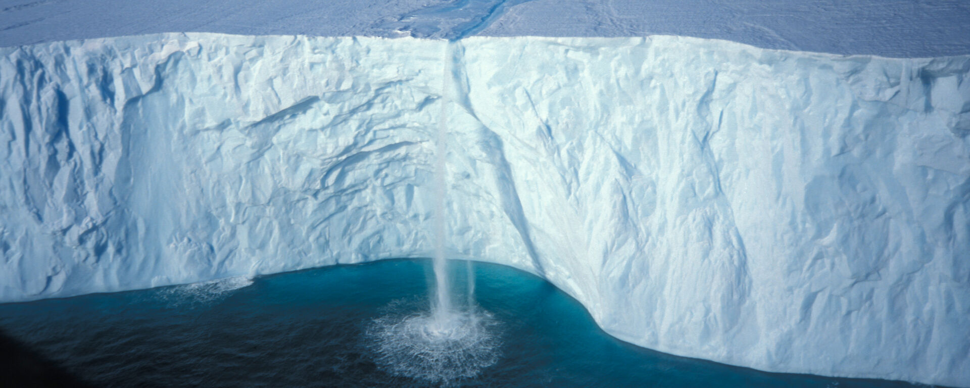 A waterfall cascading over an ice cliff.