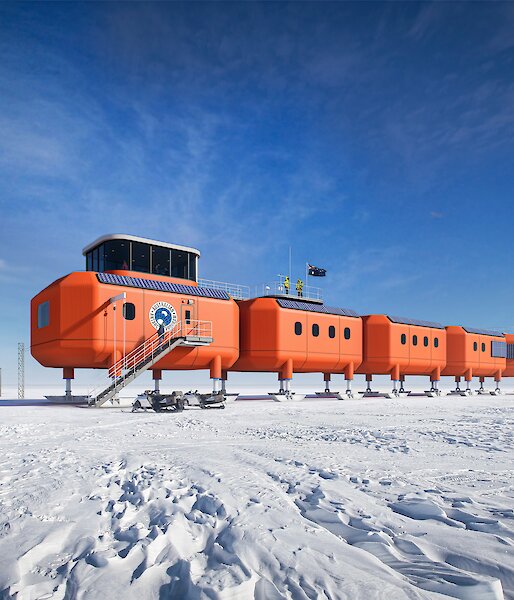 A digital rendering of large red containerised buildings on stilts in a snowy landscape.