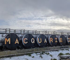 Black fuel tanks sit outside with the name Macquarie Island written on them