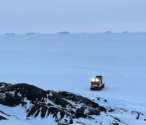 View from rocky outcrop down onto sea-ice where hagglunds is parked