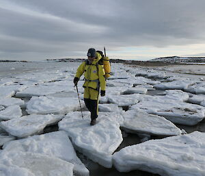 A person walking on large broken ice pieces