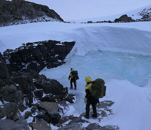 Two people walking near an ice wall