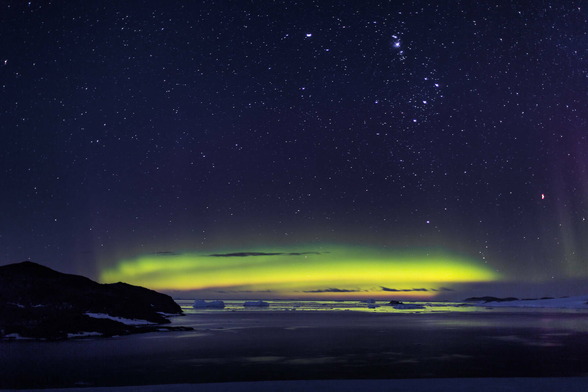 Green aurora over a bay.