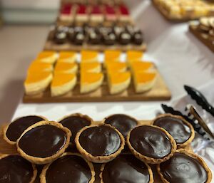 Dessert buffet table with at least eight platters each holding a different dessert cake or tart