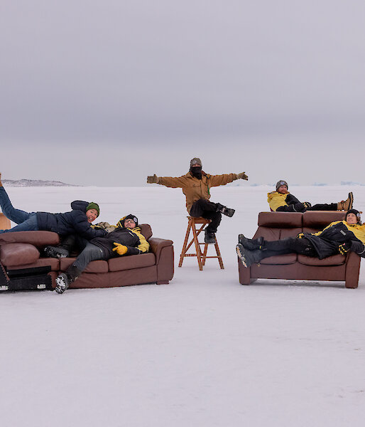 A group of people laying on couches on the sea ice
