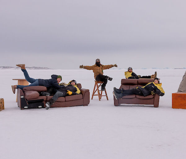 A group of people laying on couches on the sea ice