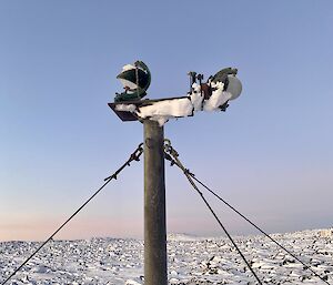 A weather instrument overlooking snow and rocks