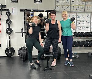3 woman holding weights at a gym