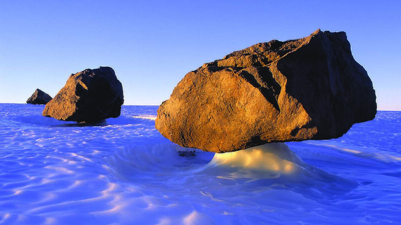 Large rocks appearing balanced on the ice