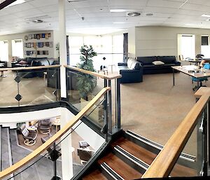 A panoramic photo of a living area, including sofas, photos and plaques hung on the wall, an air hockey table and some large, elaborate Lego constructions