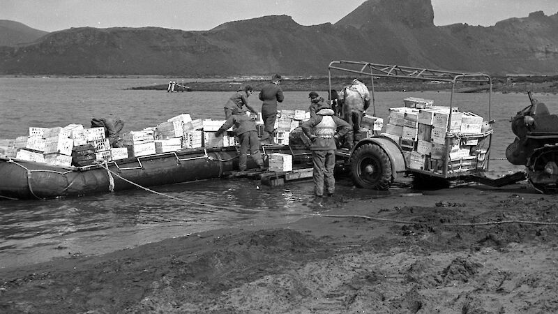 Black and white image of landing stores on beach from pontoon raft