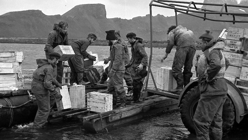 Black and white image of landing stores on beach from pontoon raft