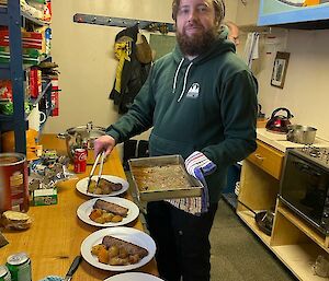 Man serving four plates for dinner in a hut