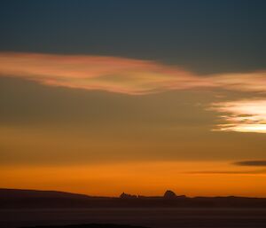 Sunset light with icebergs in distance and above the pearlescent PSCs