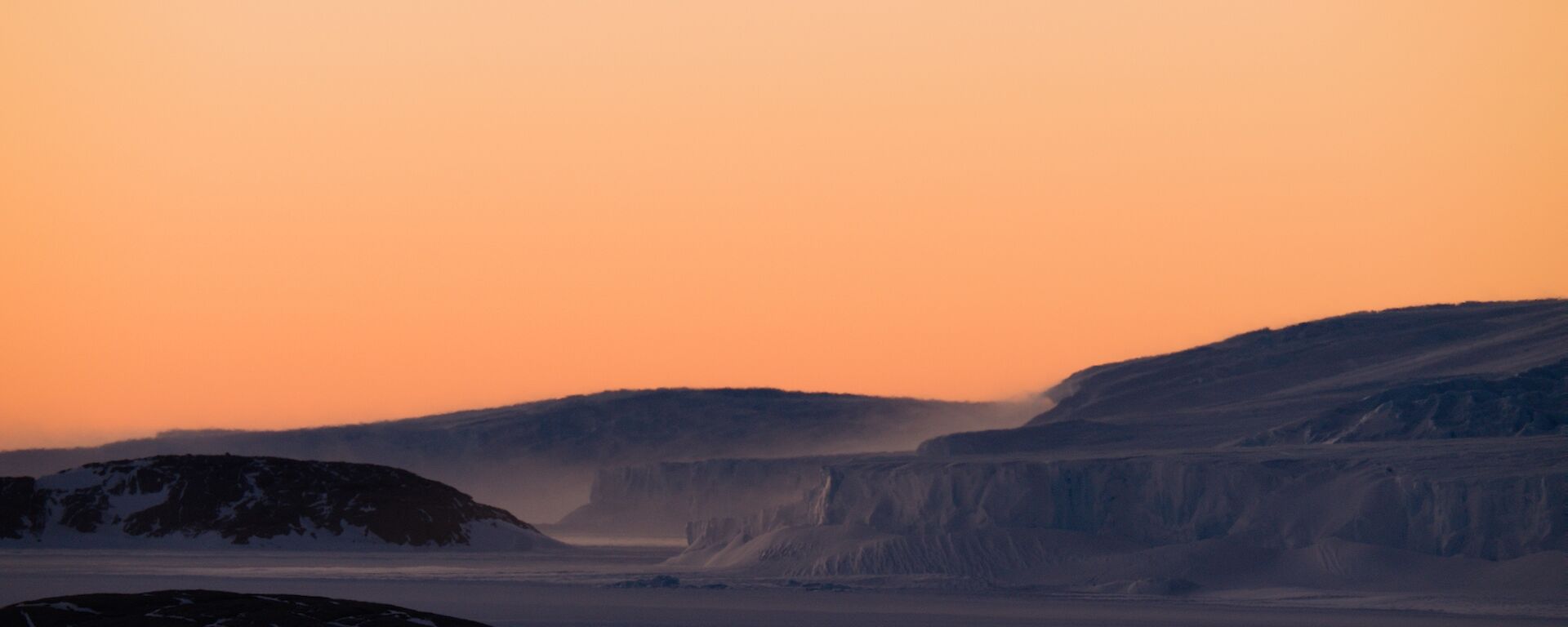 East bay coast in the dawn light with snow blowing off the edge in high winds