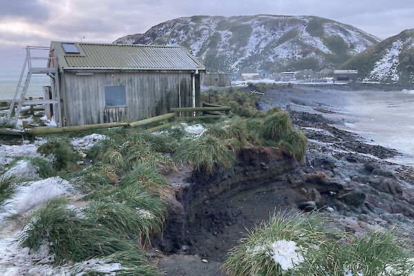 Eroded beach near building on snowy island