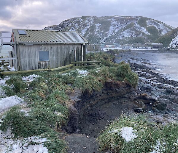 Eroded beach near building on snowy island