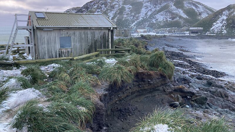 Eroded beach near building on snowy island