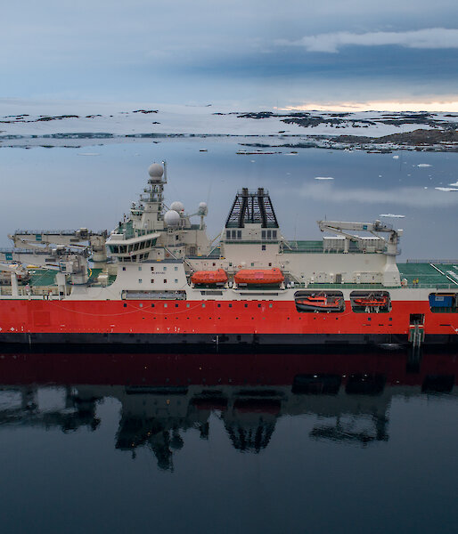 Antarctic icebreaker RSV Nuyina on a mirror-smooth bay in Antarctica.